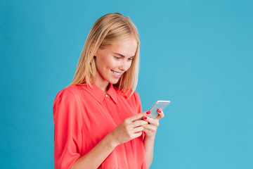 Portrait of a cheerful young blonde woman holding mobile phone