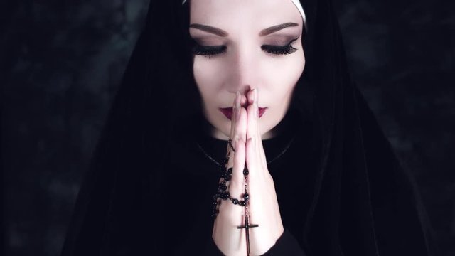 4k Halloween Shot of a Horror Nun Praying with Cross