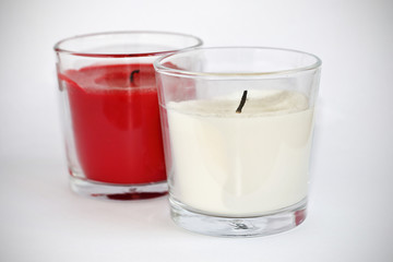 Dos velas, blanca y roja, apagadas, sobre fondo blanco