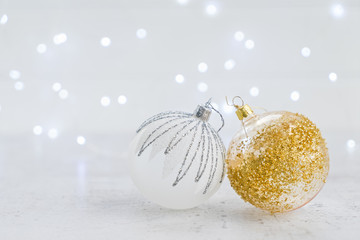 Christmas scene with white and golden balls and christmas lights in background