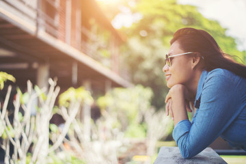 Portrait of  young hipster woman relaxing on a balcony on a sunn