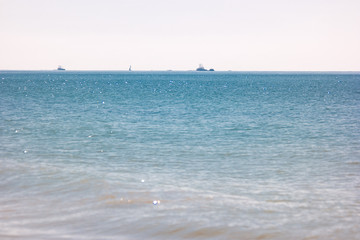 Cloudless sky and sea. Ships on horizon. Trust the compass. Long way of sailors.