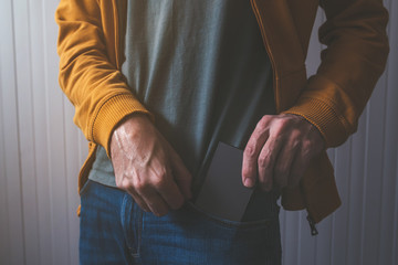 Casual adult male taking smartphone from jeans front pocket