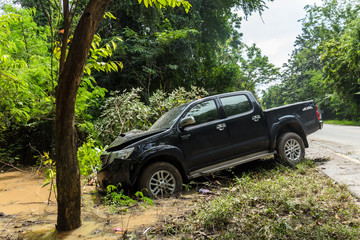 Accident car crash on an suburban street against a tree.