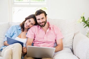 Portrait of couple using digital tablet and laptop