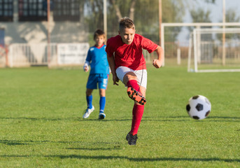 Boy kicking soccer ball