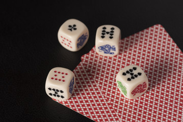 Gaming dice with cards on dark table