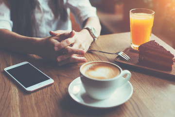 Woman with mobile phone on the table, texting in social media, breakfast of handsome business lady