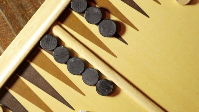 Panning shot of a backgammon board with dice, double six.