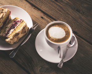 cake with raspberries and cup of coffee on a wooden table