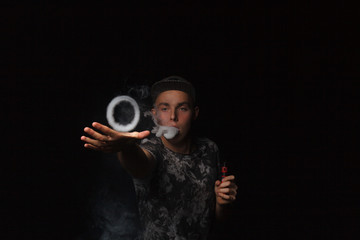 man smoking electronic cigarette lets rings of smoke