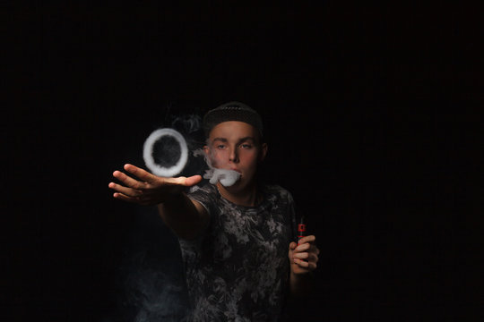 man smoking electronic cigarette lets rings of smoke