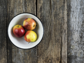 Three apples in a metal enamelled bowl