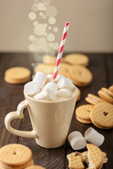Marshmallows in a Cup with cookies with hearts out of the jam.
