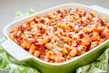 Pasta casserole with bacon, ham, cheese and tomato