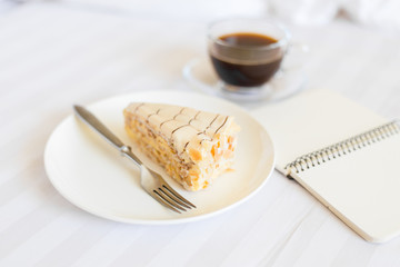 Cup of coffee with slice of cake on the bed