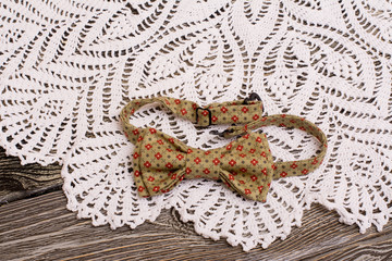 Bow tie and Crochet doily on wooden background