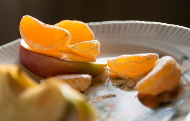 slices of mandarin and apple on a plate close-up