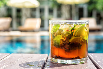 mojito cocktail on poolside. Swimming pool and resort in backgro