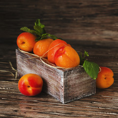 Fresh apricots in small wooden box, selective focus, top view
