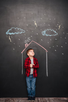 Cute kid standing in house on chalkboard with drawings