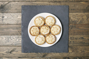 Aerial view of a plate full of freshly baked pies on a rustic wooden table background