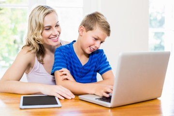 Happy mother and son using laptop