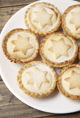 A close up of a plate full of freshly baked pies on a rustic wooden dining table background