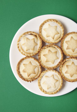 Overhead View Of A Plate Full Of Freshly Baked Mince Pies On A Green Background