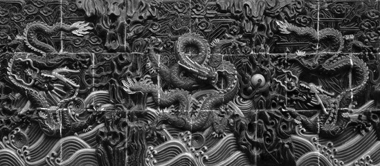 TILES OF DRAGON SCULPTURES ON THE WALL
