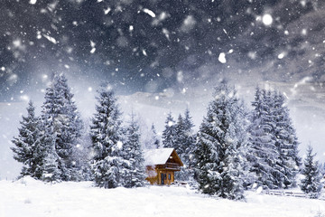 Obraz na płótnie Canvas Christmas postcard with cozy cabin in heavy winter