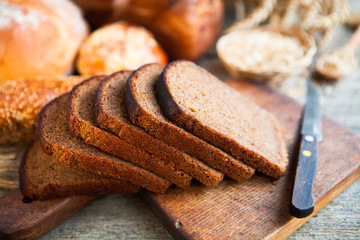 Tasty fresh bread and wheat on the old wooden table