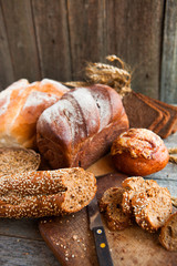 Fresh bread slice and cutting knife on rustic table