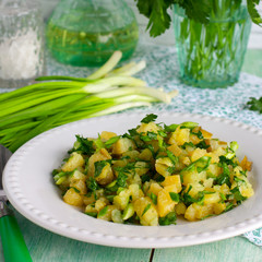 Potato salad on a white plate with fresh herbs