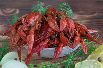 Red boiled crayfishes, fennel, onions, lemon on wooden backgroun