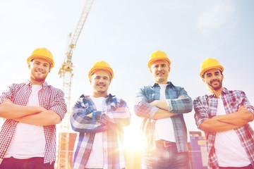 group of smiling builders in hardhats outdoors