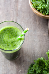 Kale smoothie in glass on wooden background.Copyspace
