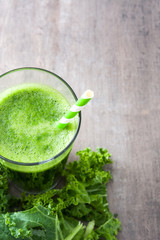 Kale smoothie in glass on wooden background.Copyspace
