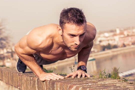 Man fitness model training pushups outdoors