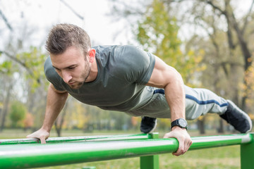 Push-ups - fitness man training push up outside.