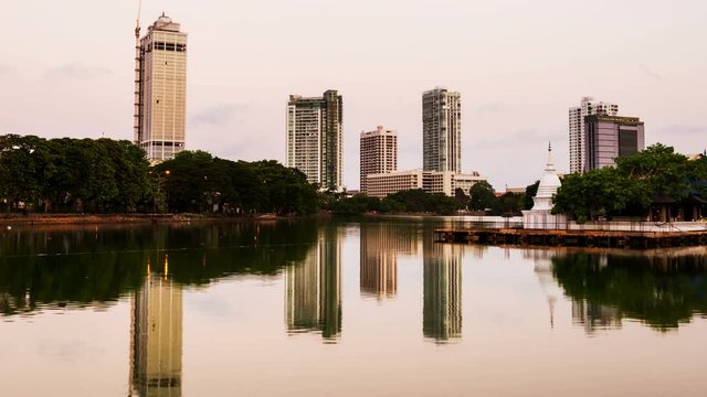 Sri Lanka. View of Beira Lake in Colombo, Sri Lanka with buddhist temple and illuminated modern buildings at sunset. Night to day time-lapse. Clear sky