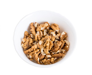 Pile of walnuts in white bowl.