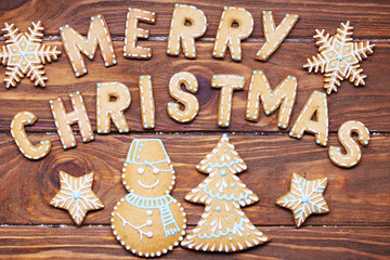 Christmas card. Christmas sign with ginger cookies on a wooden background. Christmas treat decorating. Top view.