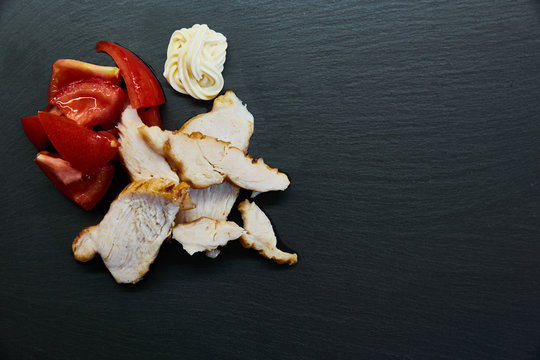 Straccetti di pollo alla griglia con pomodori su fondo lavagna