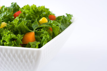 Kale salad in bowl with carrot, pepper and sweet corn isolated on white background
