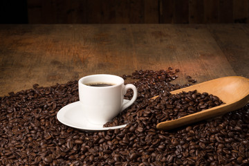 coffee cup on bed of roasted beans with serving spoon and room for copy