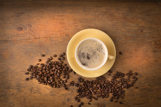 Coffee Mug With Spilled Beans On Wooden Surface Topview