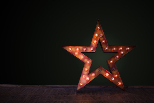 Decorative star with lamps on a background of wall. Modern grungy interior

