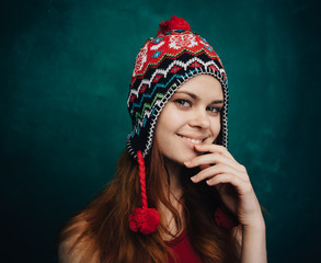 Pretty smiling woman in a funny hat on bright background
