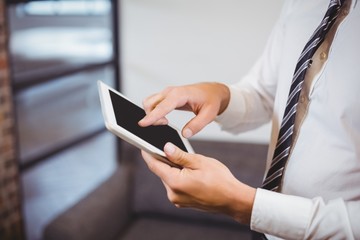 Midsection of businessman using digital tablet